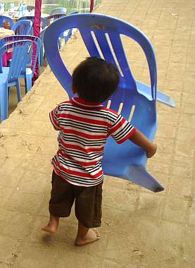 Toddler carrying a chair